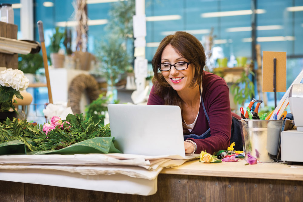 Flower shop owner working on computer