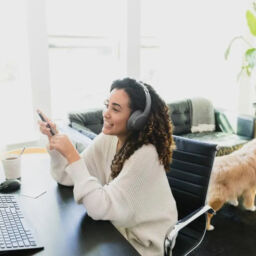 Remote work employee on conference call while child and pet play in background.