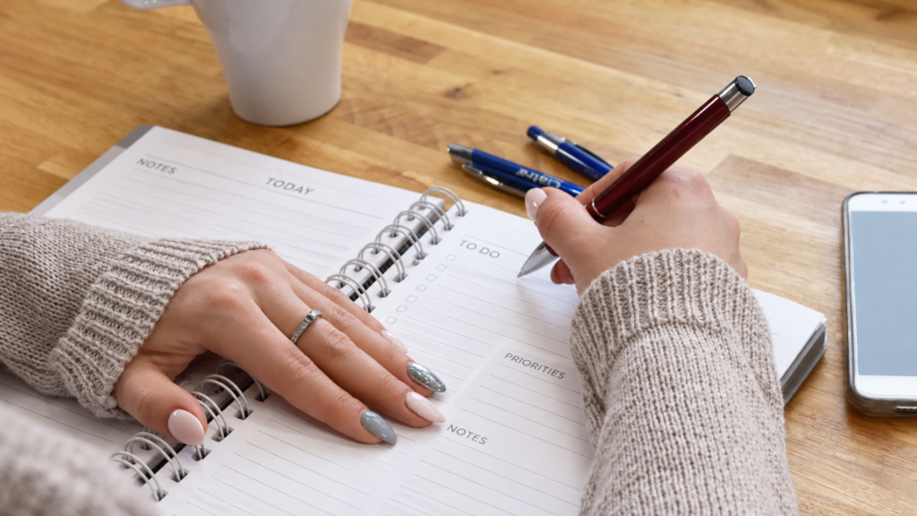 Woman writing in a planner.